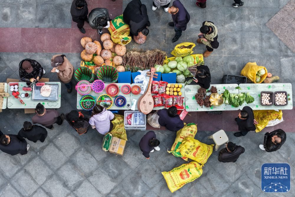 ↑12月13日，居民在陇南市武都区“冬至大集”上选购特色农产品（无人机照片）。