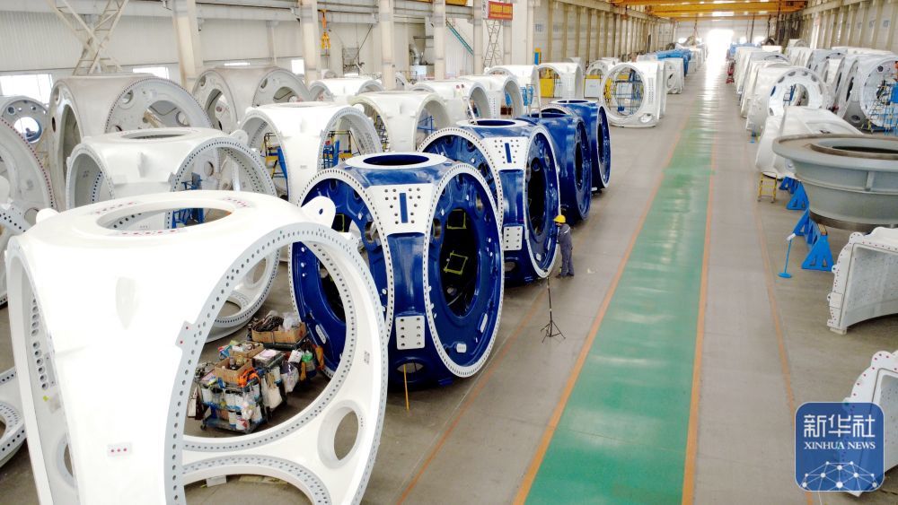 ↑ 12月15日，工人在山东省滨州市惠民经济开发区风电装备产业园的车间清理风电轮毂（无人机照片）。新华社发（王军摄）