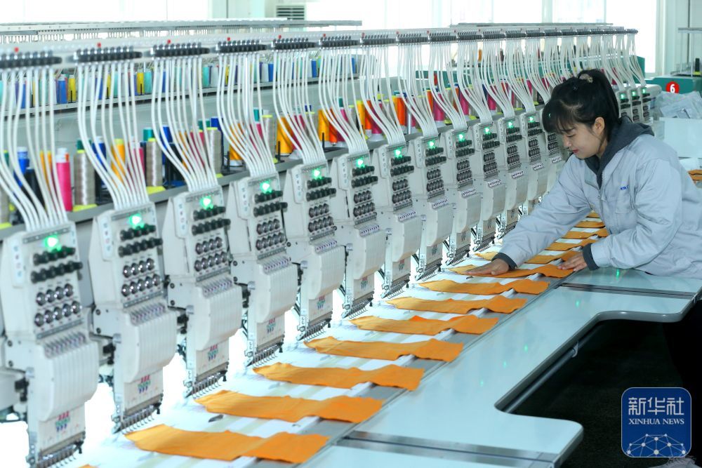 ↑ 12月15日，山东省青岛市即墨区即发集团员工在生产服装绣花产品。新华社发（梁孝鹏摄）