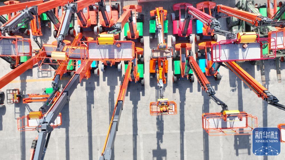 ↑ 12月15日，在位于浙江省湖州市德清县雷甸镇的浙江鼎力机械股份有限公司，工人对准备出口的新臂式智能高空作业平台设备进行检测（无人机照片）。新华社发（谢尚国摄）