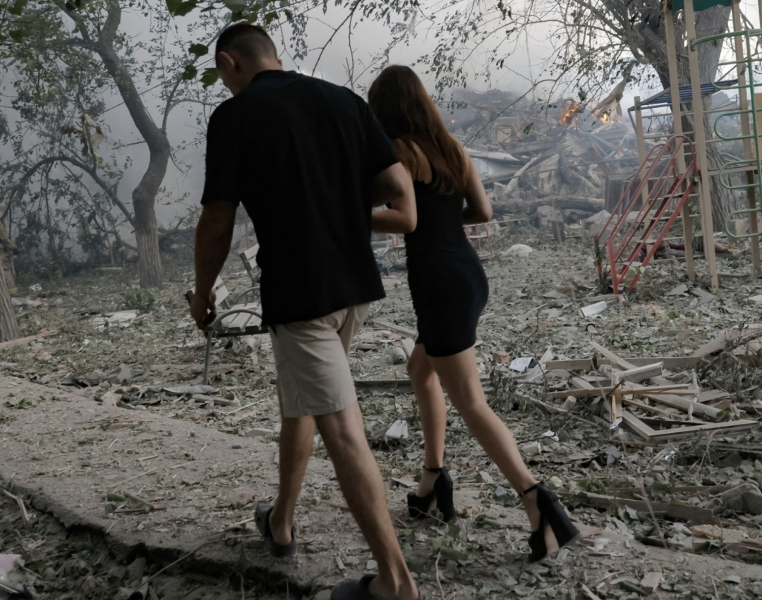 ▎乌克兰克拉马托尔斯克,居民们走过一处被俄罗斯空袭摧毁的民宅现场。图源:AP