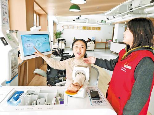 12月6日，在廊坊市广阳区都市花园社区居家享老服务中心，63岁的张萍老人正在使用智慧健康一体机测量血压。本报记者 刘杰摄