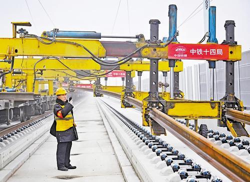 12月19日，中铁十四局建设者在京港高铁雄商段进行铺轨施工。 本报记者 张 昊摄