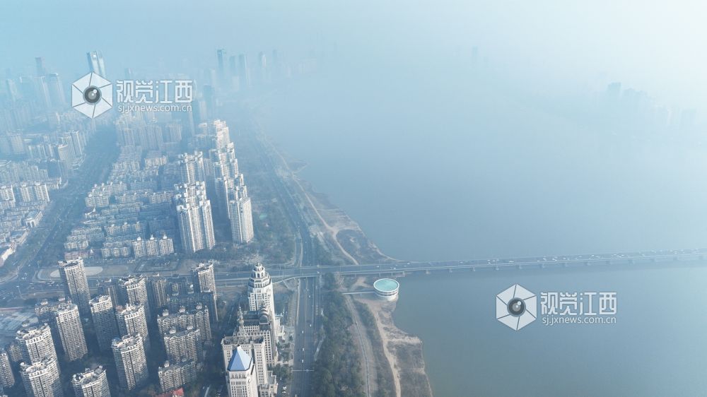 12月19日上午，航拍镜头中的南昌赣江两岸，高层建筑在雾霾中若隐若现。