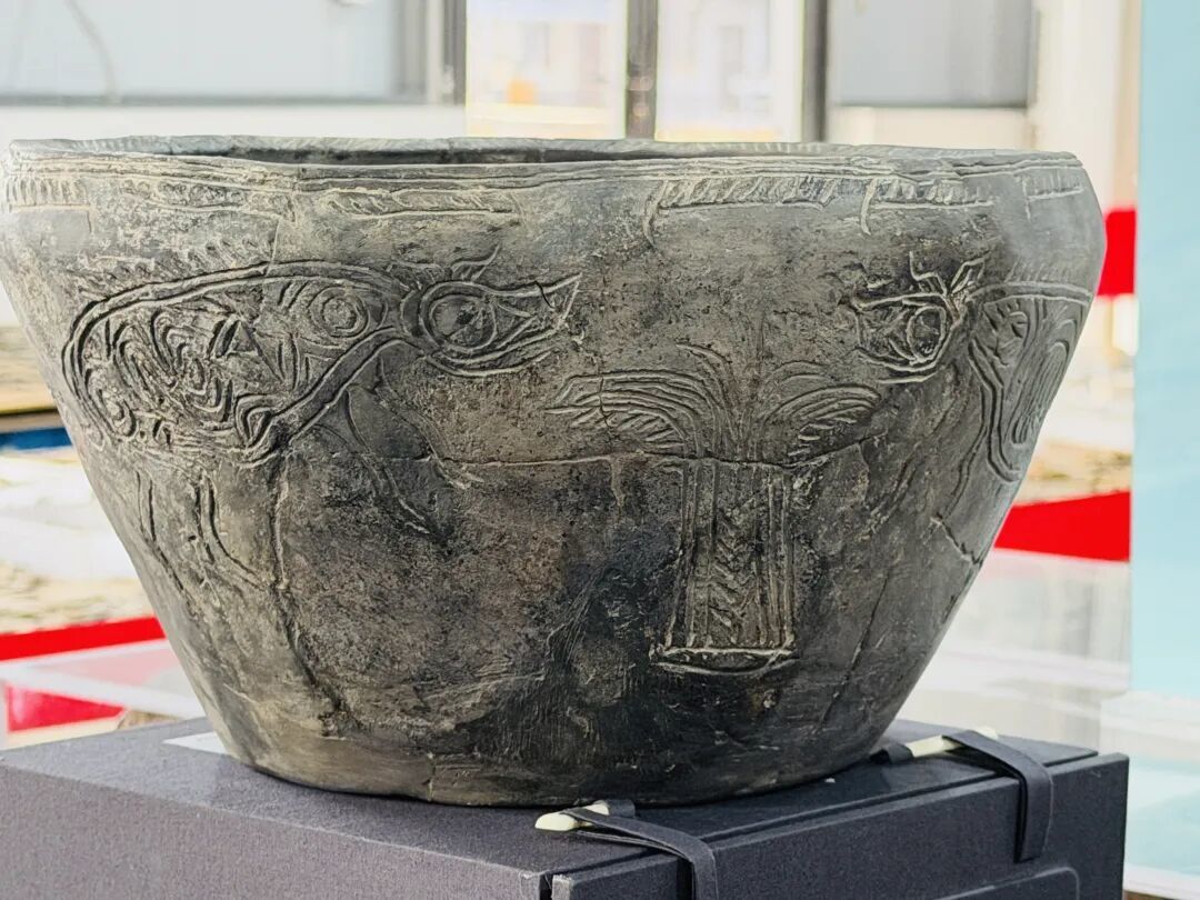 刚修复完成的田螺山遗址出土陶器，上面有明显的稻穗纹和猪纹。