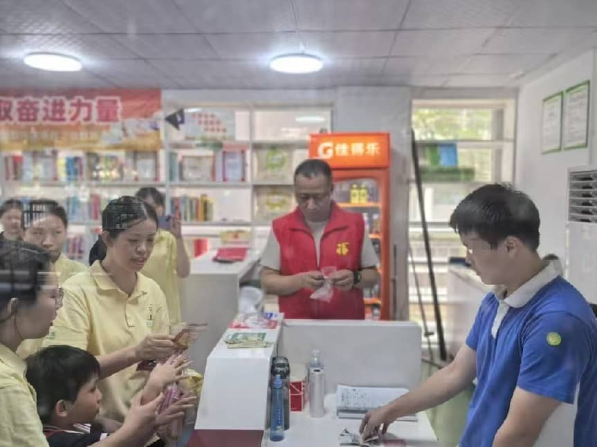 图为文文为儿童院的弟弟妹妹和老师们挑选的小零食扫码买单