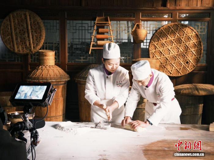 图为梁晶(图左)和父亲梁启标(图右)在制作茶饼。　受访者供图