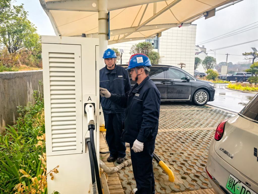 国网孝昌县供电公司工作人员正在检查充电桩情况。新华社记者 田中全 摄