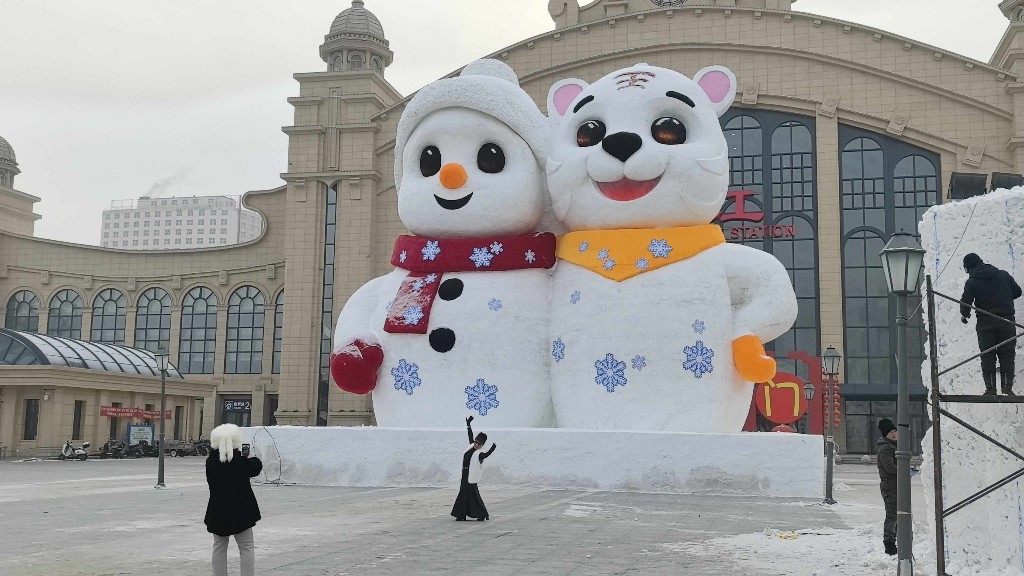 市民在大雪人前跳舞拍照