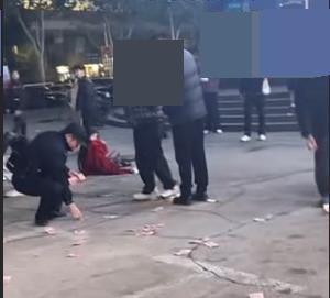 情侣酒后争吵女子街头撒钱 民警现场拾回