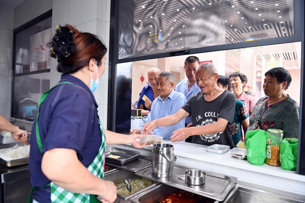 2025年6月22日，老年人在浙江衢州常山县球川镇的“幸福食堂”排队取餐。新华社记者金良快摄