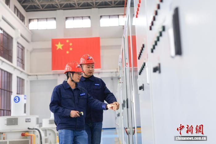 12月23日,三峡集团的技术人员对八赛枢纽的设备进行巡检。中新社记者 贾天勇 摄