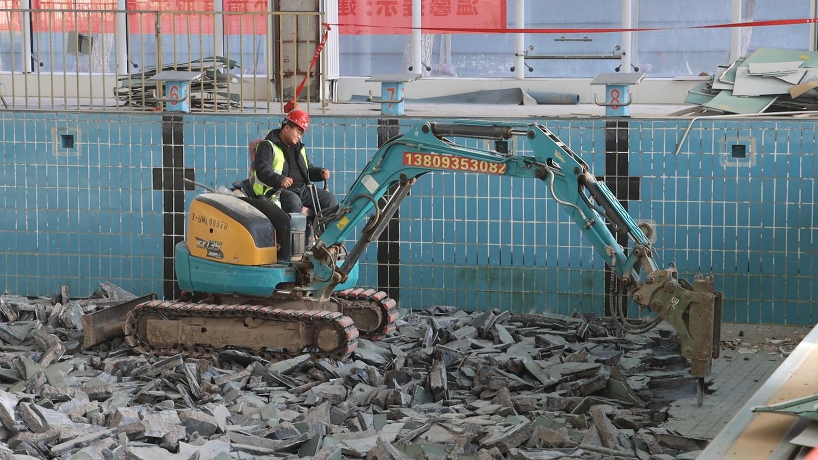 △液压破碎锤挖掘机正在将泳池内的旧瓷砖逐一破碎清理