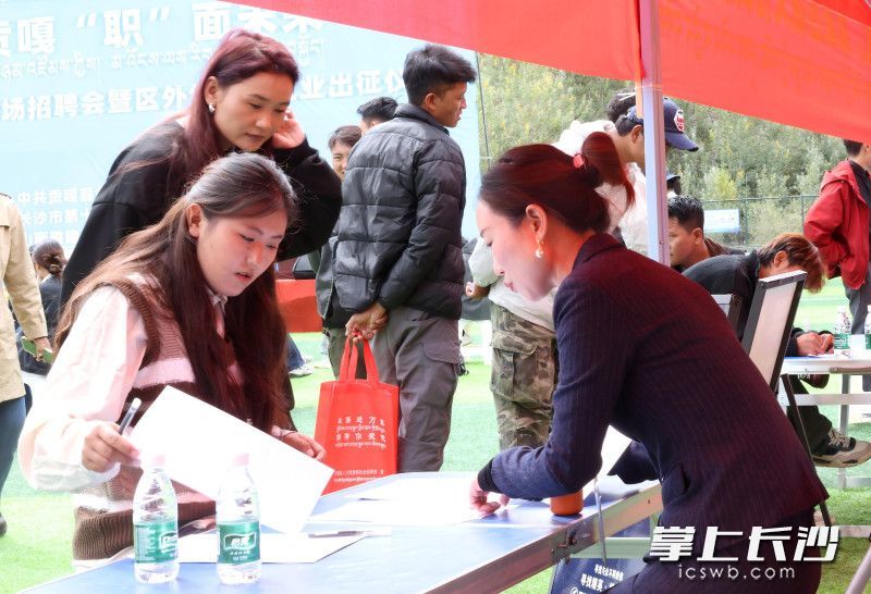 2025年9月11日，“湘约贡嘎 ‘职’面未来”就业援藏专场招聘会举行。图为求职者在长沙企业展位前填写登记表。