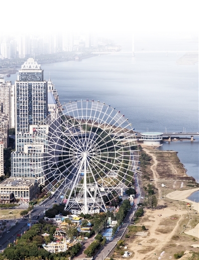 摩天轮矗立江畔，与城市建筑、粼粼的赣江水相映成画
