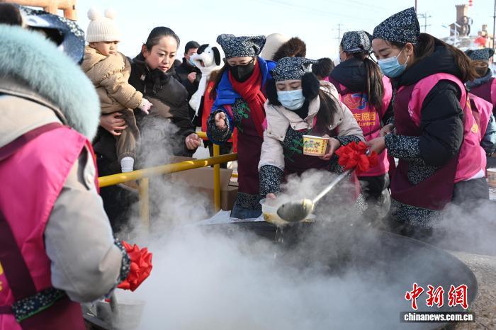 图为工作人员为民众分发“牛娃子饭”　戴文昌　摄