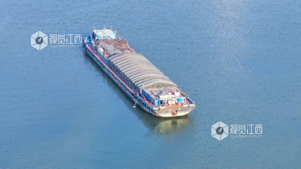 2025年12月20日,江西省吉安市港口物流有限责任公司综合货运码头赣江水域上,多艘货船正待装货或已装满货物,少数满仓货船缓慢驶离岸边,年末来临之际一派繁忙景象。