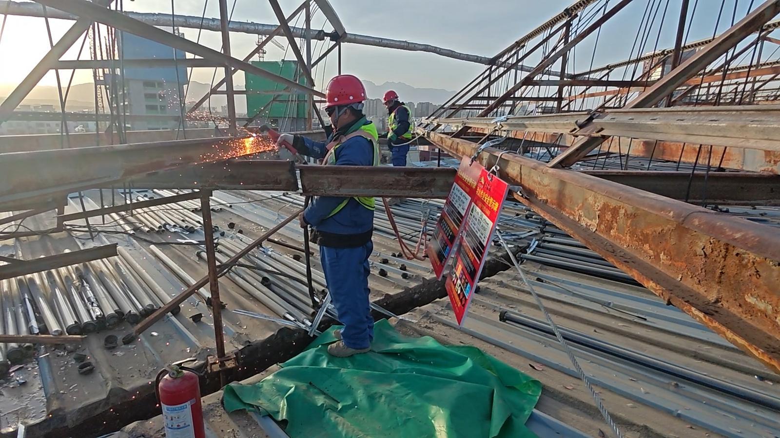 △工人们正在拆除市游泳馆屋顶固定太阳能的支架