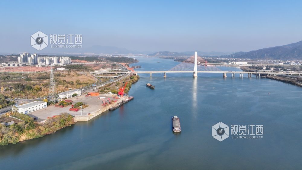 2025年12月20日,江西省吉安市港口物流有限责任公司综合货运码头赣江水域上,多艘货船正待装货或已装满货物,少数满仓货船缓慢驶离岸边,年末来临之际一派繁忙景象。