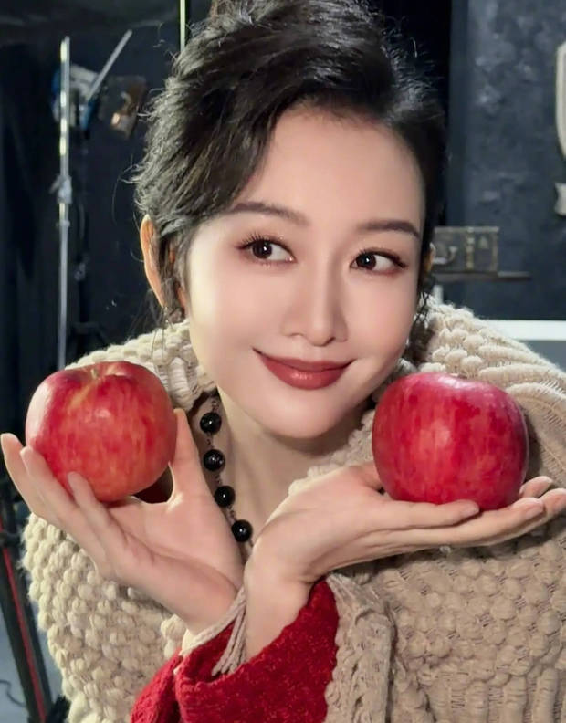 王鸥手拿两个苹果拍照。