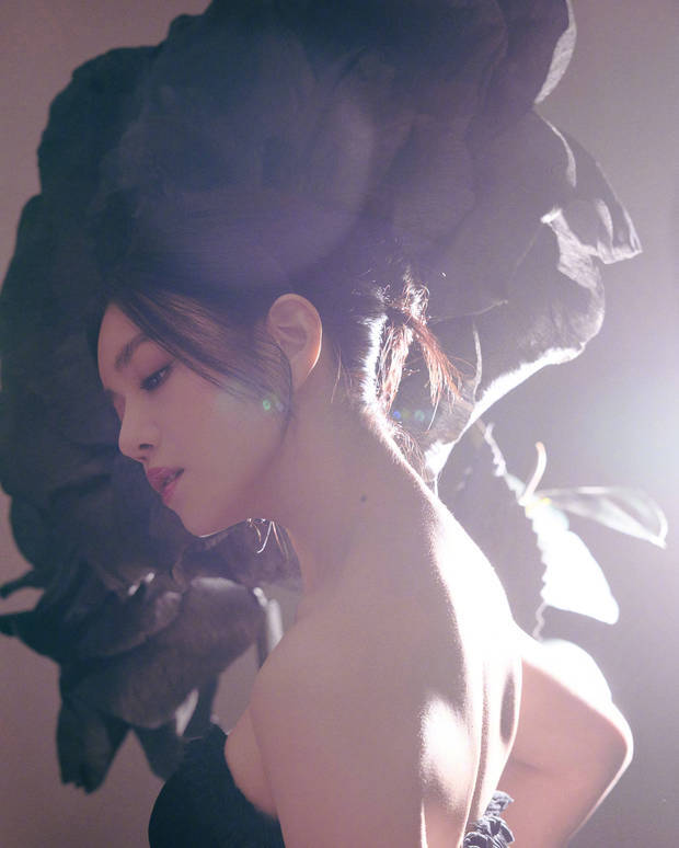 陈妍希侧颜出镜，发丝与巨型黑玫瑰相融，暖光勾勒肩颈线条，神态松弛冷艳。