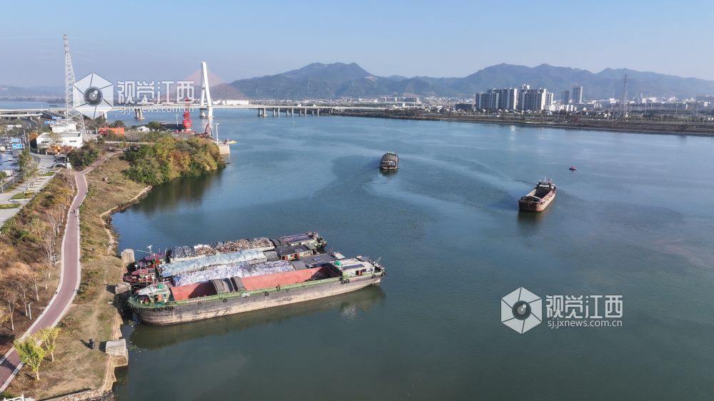 2025年12月20日,江西省吉安市港口物流有限责任公司综合货运码头赣江水域上,多艘货船正待装货或已装满货物,少数满仓货船缓慢驶离岸边,年末来临之际一派繁忙景象。