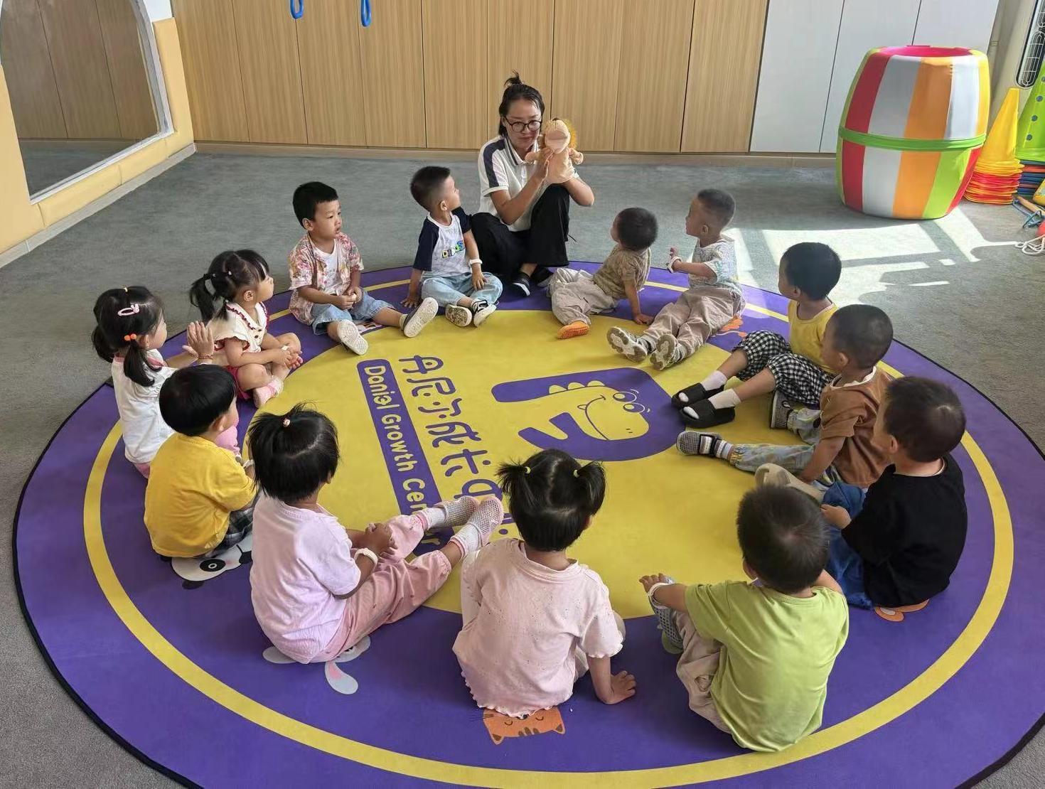 △丹尼尔早教托育中心的老师带着小朋友们做游戏