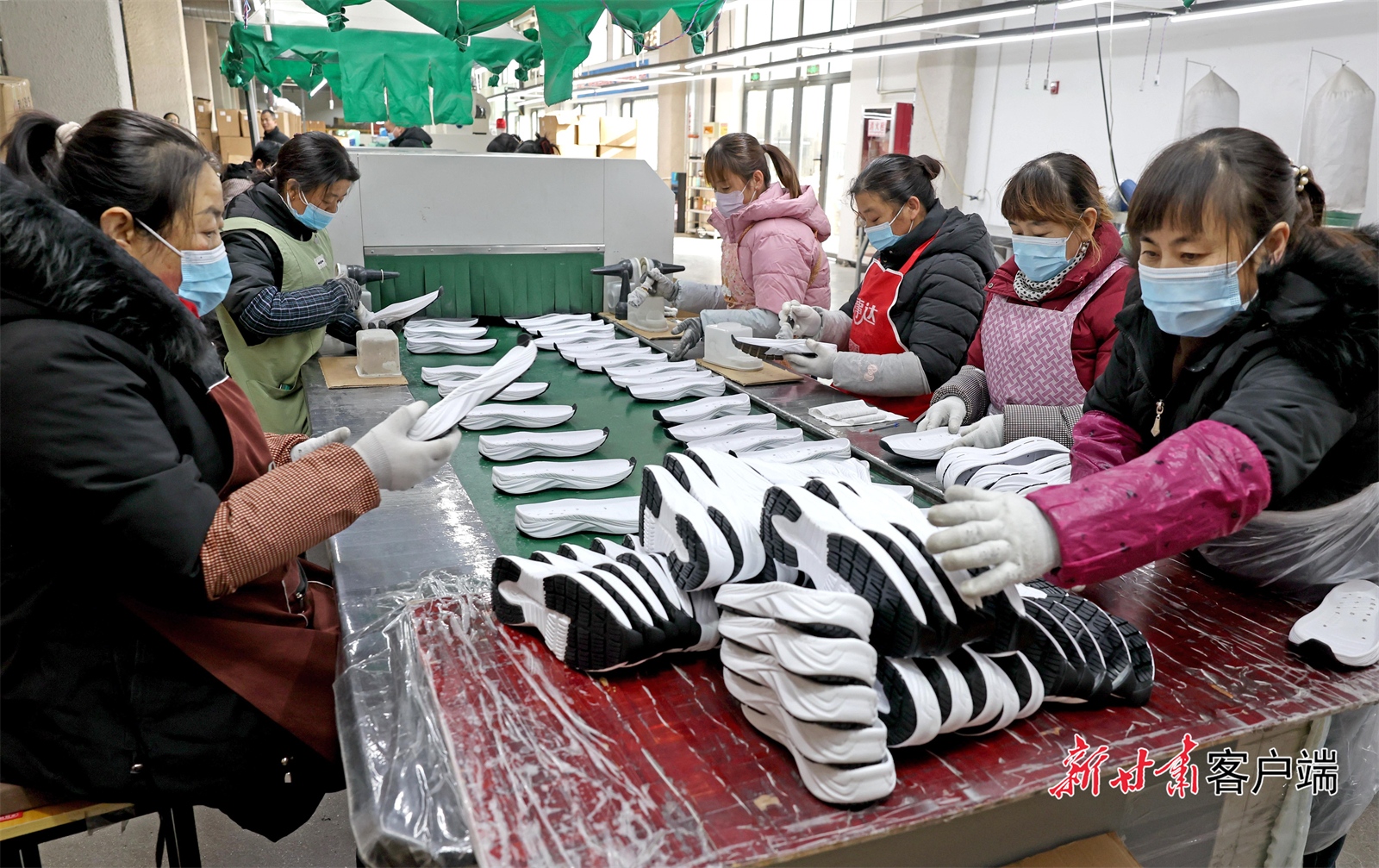 工人们正在给鞋底涂胶