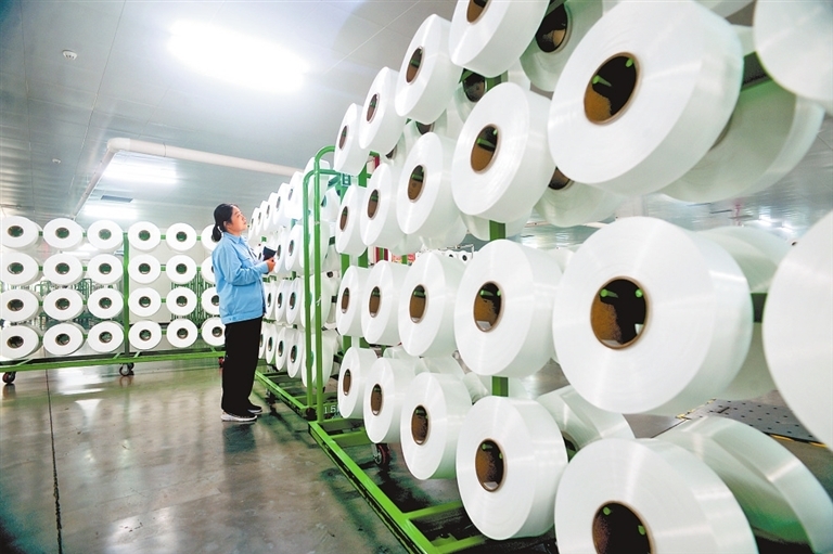 河南神马锦纶科技有限公司尼龙6民用丝一期项目正抓紧生产，职工查看尼龙6丝饼外观质量。 齐磊 摄