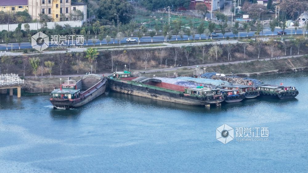 2025年12月20日,江西省吉安市港口物流有限责任公司综合货运码头赣江水域上,多艘货船正待装货或已装满货物,少数满仓货船缓慢驶离岸边,年末来临之际一派繁忙景象。
