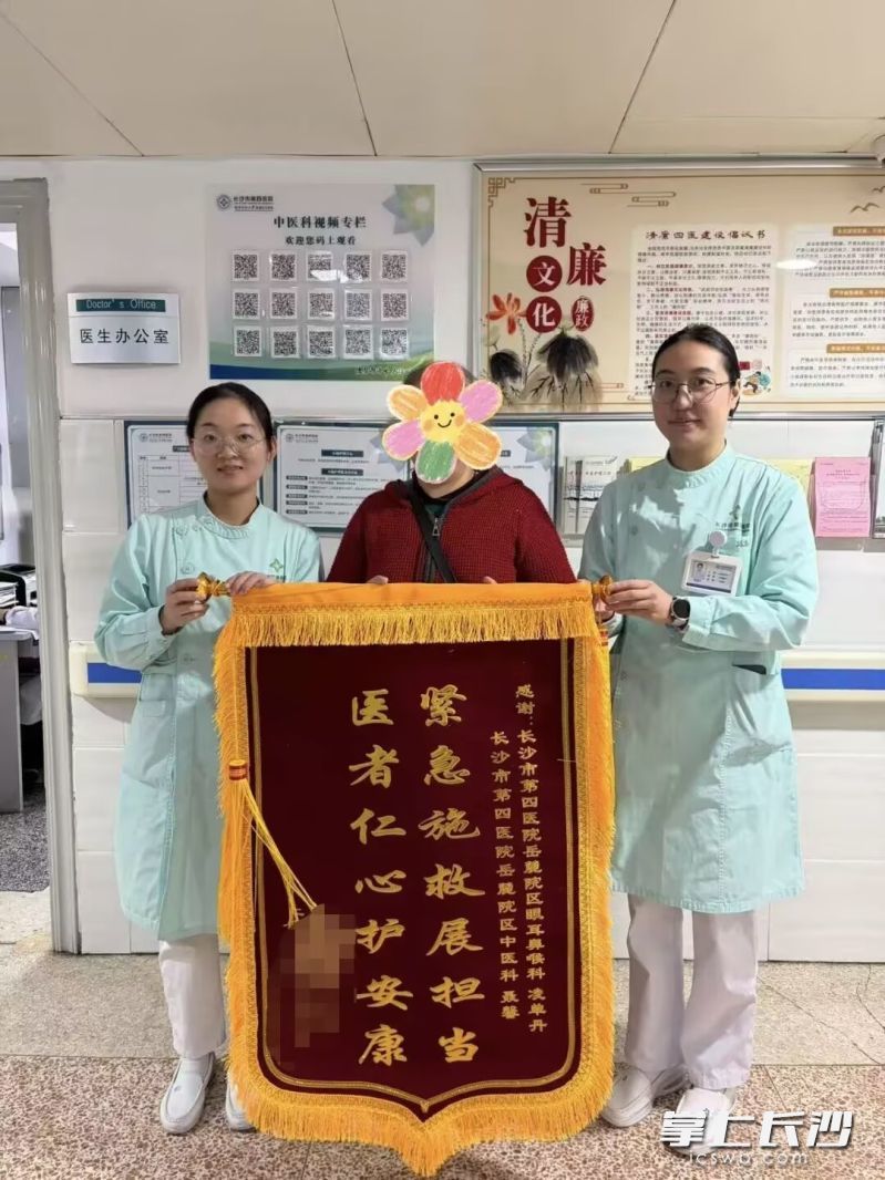 陈先生将一面锦旗送到长沙市第四医院耳鼻喉科护士凌单丹（右一）、中医科护士聂馨（左一）手中。 受访者供图