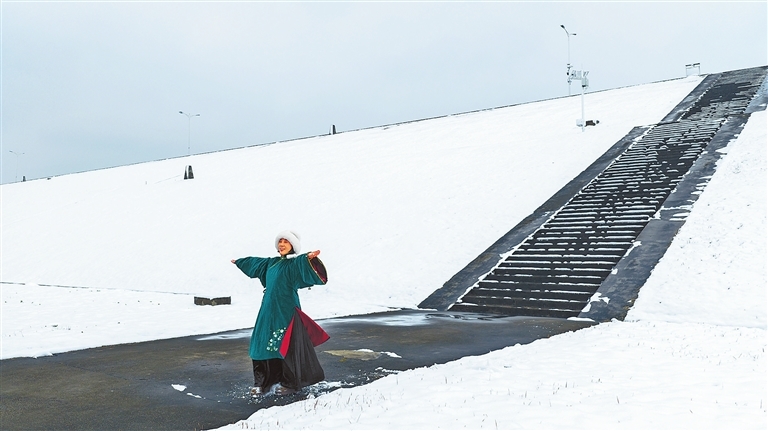 1月1日，光山县泼河水库，瑞雪覆盖了堤坝，游客身着汉服在雪中拍照，尽显韵味。晏荣荣 摄