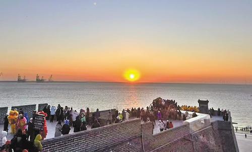 1月1日早晨，游客在秦皇岛市山海关区老龙头景区观看海上日出。 本报记者 张辉摄