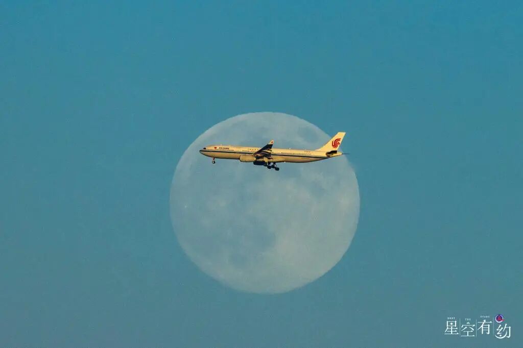 2025年12月4日晚,在北京市拍摄的一架飞机飞过超级月亮。(吴鲁萍/摄)图源:新华网