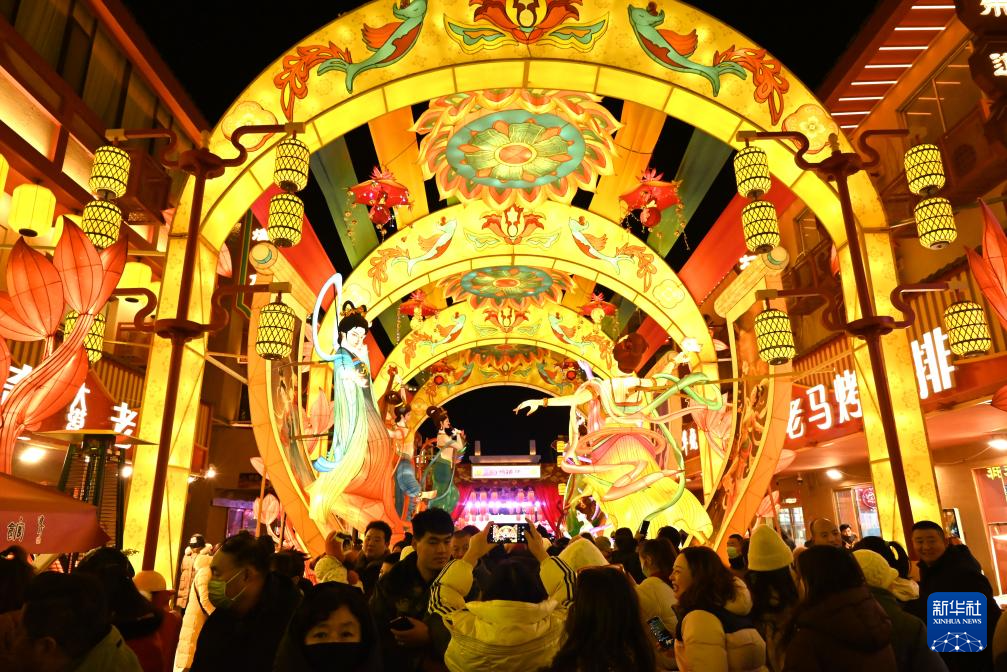 12月31日，游客在甘肃敦煌夜市举办的敦煌灯会上欣赏花灯。