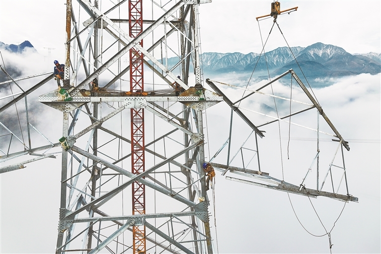 2025年11月20日，四川省阿坝藏族羌族自治州茂县富顺镇境内，绵延的高山之巅云遮雾绕，江西省送变电工程有限公司的工人们爬上高塔进行组塔作业。