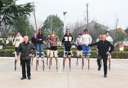 王成林（左）、杨民杰（右）向小走兽演员亲授高跷表演技艺。