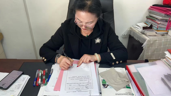 图：张有仙整理完善客户调查问卷