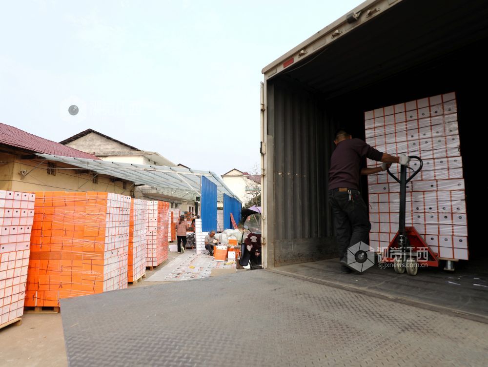 村民在家门口有序制作鞋子包装盒。