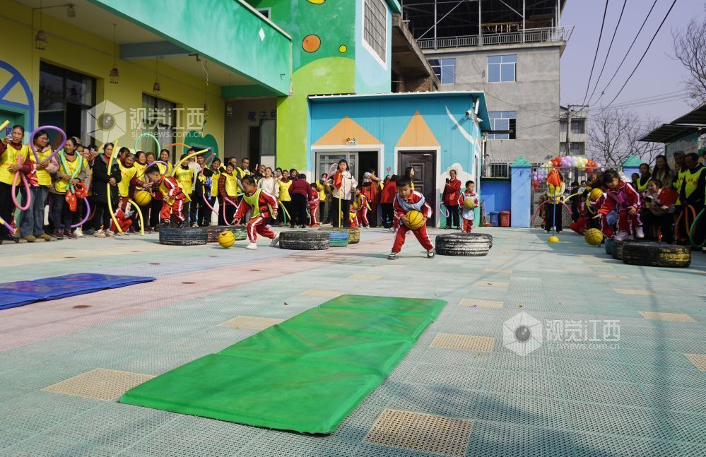 2026年1月4日，江西遂川县珠田镇育苗幼儿园里热闹非凡，一场亲子互动趣味运动会欢乐开启。萌娃们抱着篮球闯关卡：推轮胎、过木梯、翻垫子，动作利落又可爱；家长们手持彩圈助威，现场笑声与掌声交织。