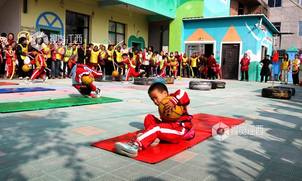2026年1月4日，江西遂川县珠田镇育苗幼儿园里热闹非凡，一场亲子互动趣味运动会欢乐开启。萌娃们抱着篮球闯关卡：推轮胎、过木梯、翻垫子，动作利落又可爱；家长们手持彩圈助威，现场笑声与掌声交织。