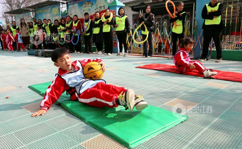 2026年1月4日，江西遂川县珠田镇育苗幼儿园里热闹非凡，一场亲子互动趣味运动会欢乐开启。萌娃们抱着篮球闯关卡：推轮胎、过木梯、翻垫子，动作利落又可爱；家长们手持彩圈助威，现场笑声与掌声交织。