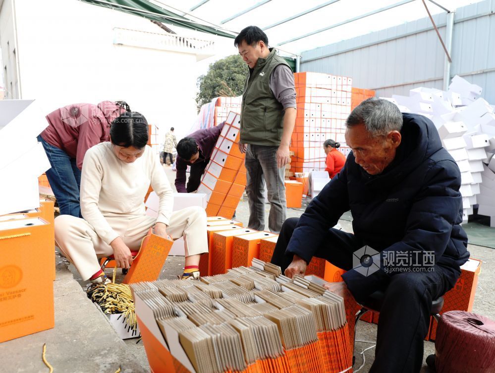 村民在家门口有序制作鞋子包装盒。