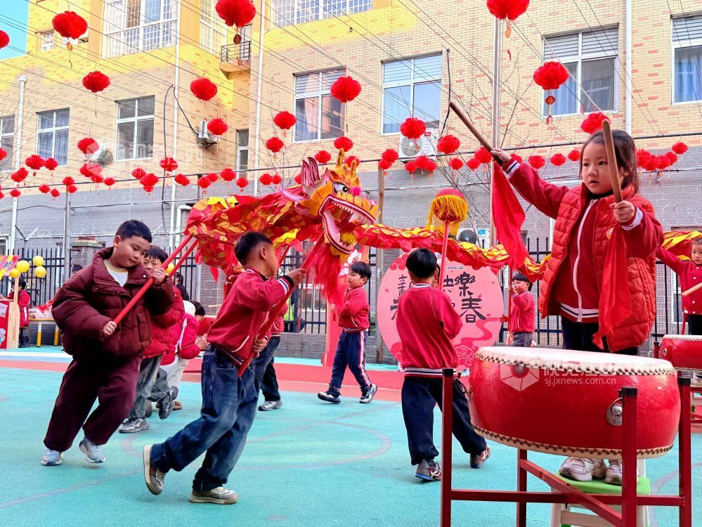 小朋友在幼儿园内舞龙舞狮，喜迎新年到来。