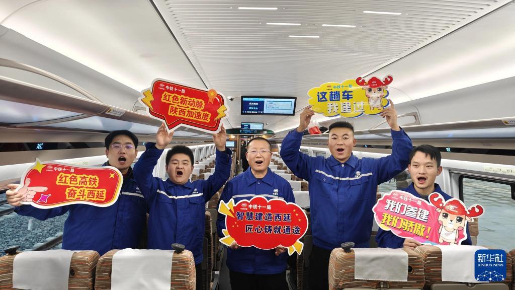 2025年12月26日，建设者在西延高铁的首发列车上合影留念。新华社记者 邢广利 摄