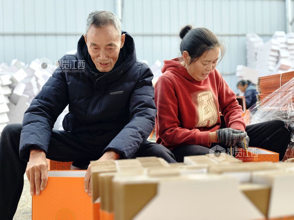 村民在家门口有序制作鞋子包装盒。