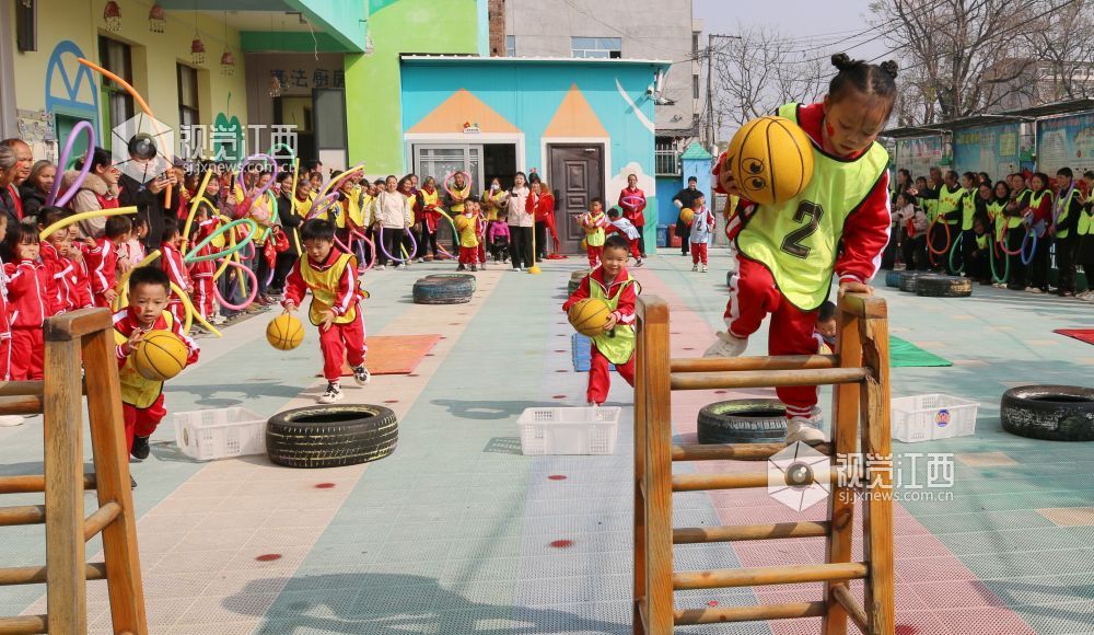 2026年1月4日，江西遂川县珠田镇育苗幼儿园里热闹非凡，一场亲子互动趣味运动会欢乐开启。萌娃们抱着篮球闯关卡：推轮胎、过木梯、翻垫子，动作利落又可爱；家长们手持彩圈助威，现场笑声与掌声交织。