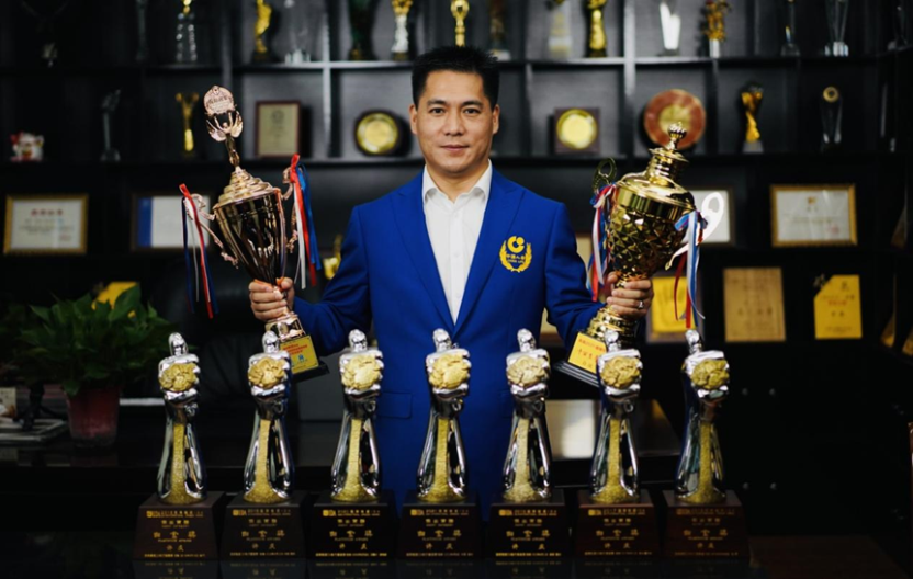 （图：许庆与获得的荣誉奖杯合照）