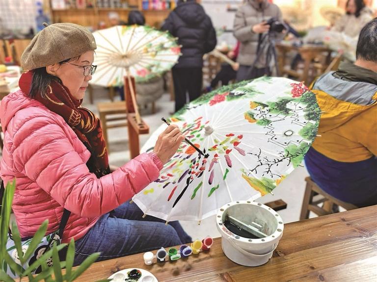 香港游客在婺源非遗体验中心绘制油纸伞。