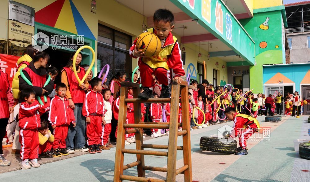2026年1月4日，江西遂川县珠田镇育苗幼儿园里热闹非凡，一场亲子互动趣味运动会欢乐开启。萌娃们抱着篮球闯关卡：推轮胎、过木梯、翻垫子，动作利落又可爱；家长们手持彩圈助威，现场笑声与掌声交织。